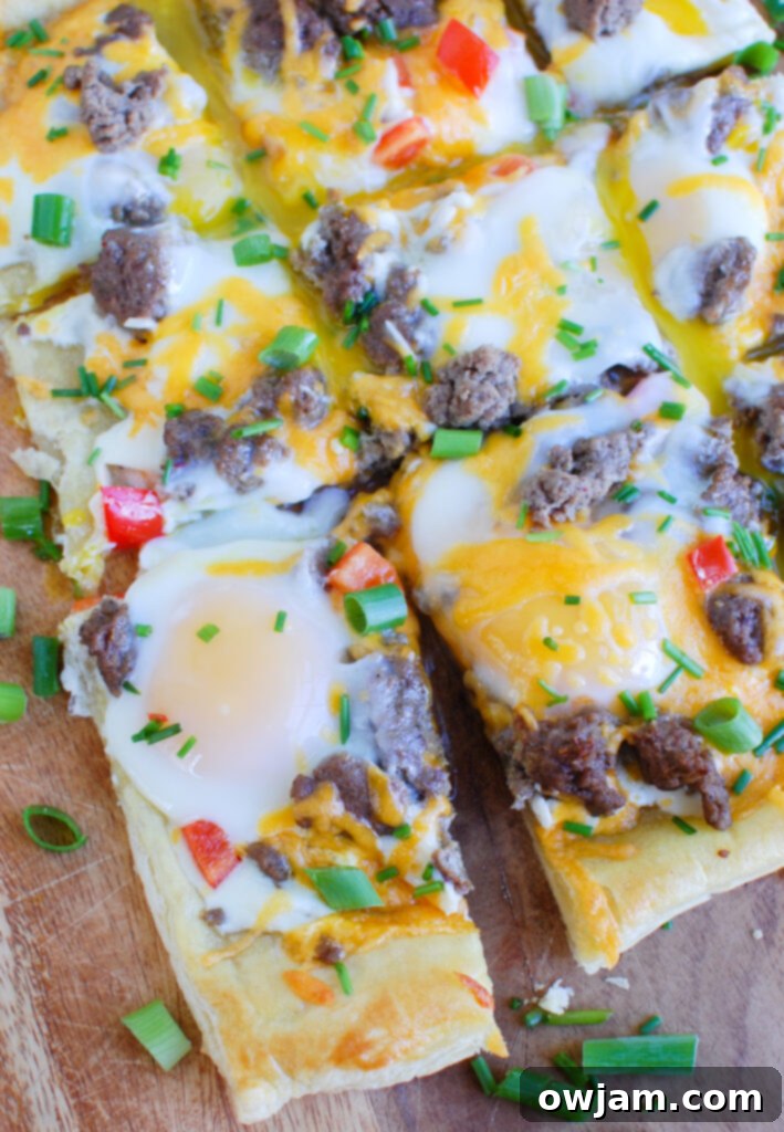 A slice of Turkey Sausage and Egg Puff Pastry Pizza showing its layers