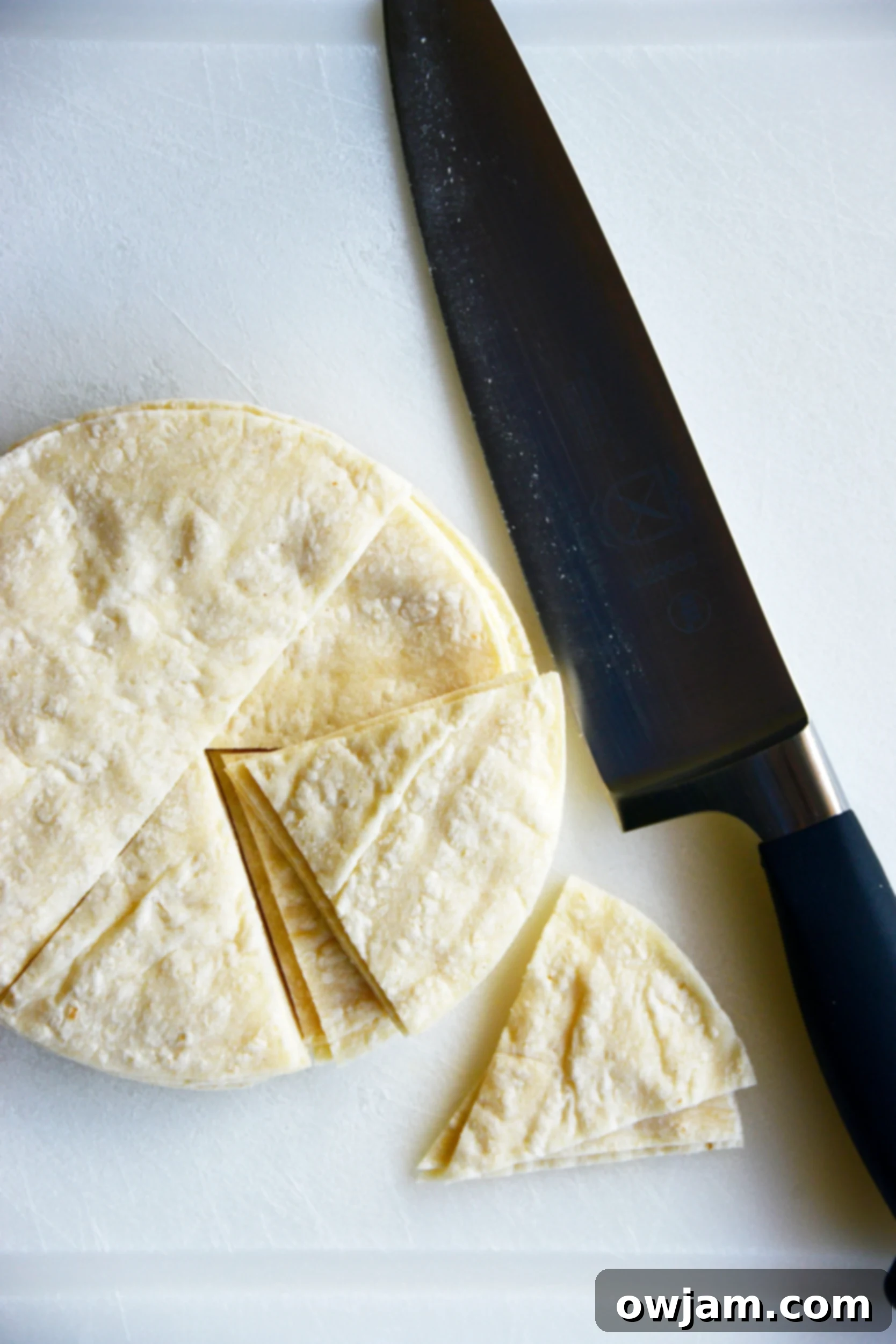 Corn tortillas expertly cut into uniform triangles, ready for seasoning.