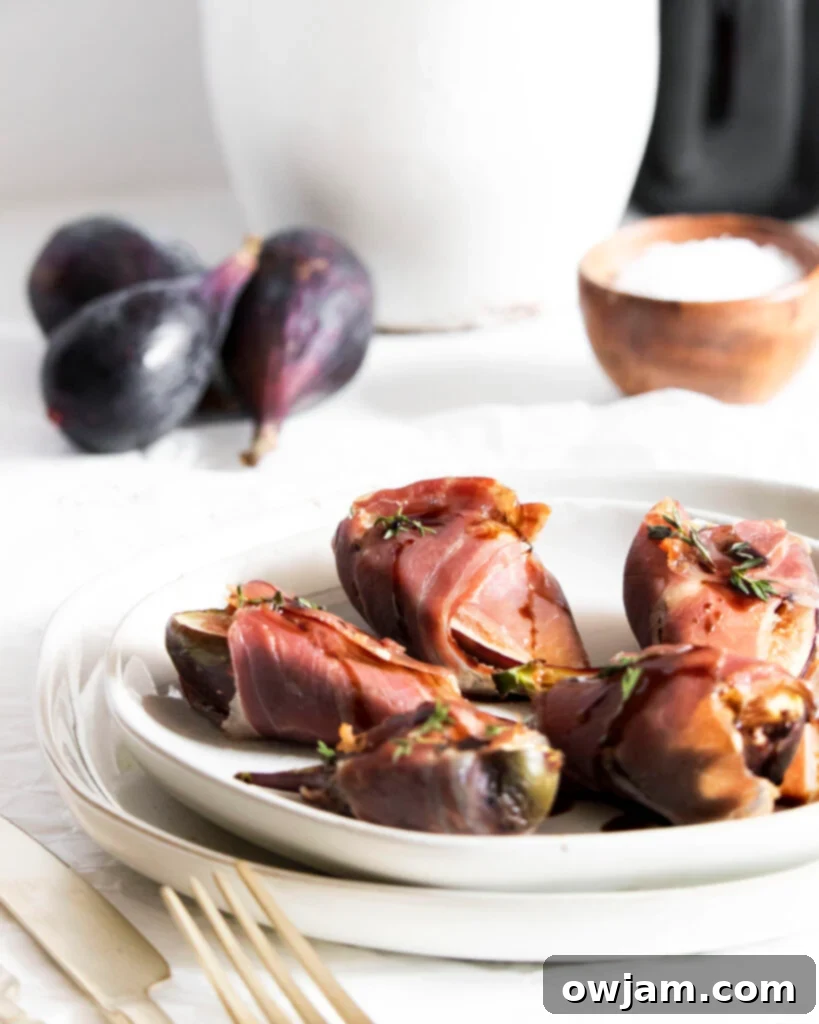 Prosciutto Wrapped Fig Goat Cheese Delights 2 Goat Cheese Figs Wrapped in Prosciutto on a white plate, drizzled with balsamic and honey