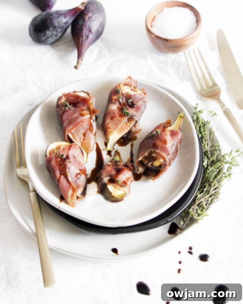 Prosciutto Wrapped Fig Goat Cheese Delights 4 Goat Cheese Figs Wrapped in Prosciutto arranged on a baking sheet, ready for broiling