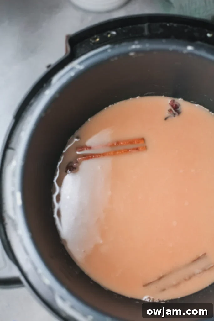 Close-up of Instant Pot Chai Tea Latte being prepared in the pressure cooker, showing the rich color of the tea and spices.