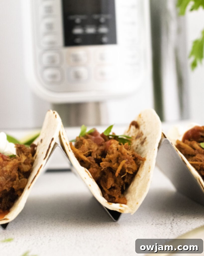 Instant Pot Carnitas Recipe tacos in a taco holder 