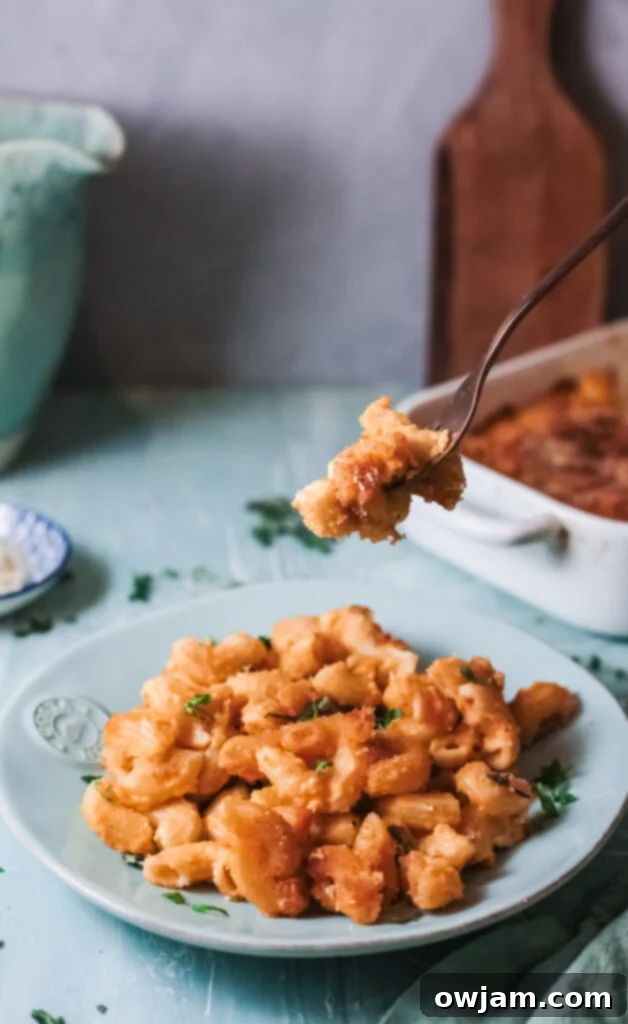 Creamy Pumpkin Mac and Cheese 3 Pumpkin Mac and Cheese with a fork lifting a creamy bite, showcasing the rich texture.