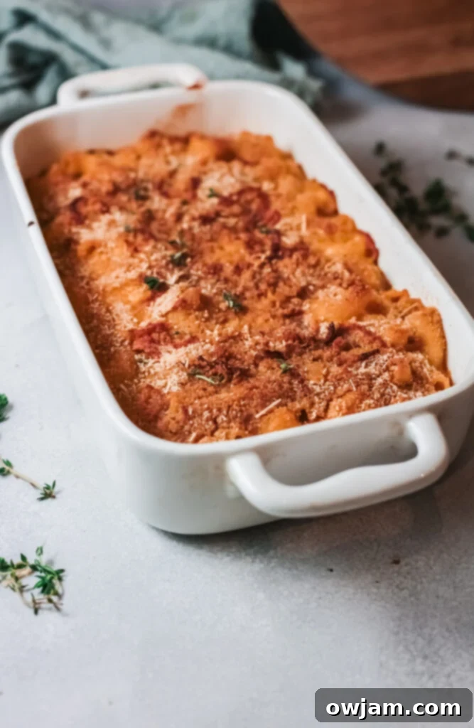 Creamy Pumpkin Mac and Cheese 4 Pumpkin Mac and Cheese in a white baking dish, showing the delicious golden-brown topping before serving.
