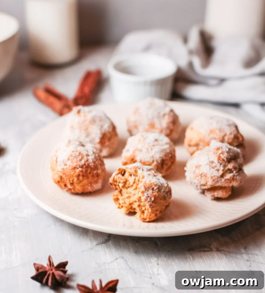 A plate piled high with freshly made Air Fryer Donut Holes, generously coated in cinnamon sugar.