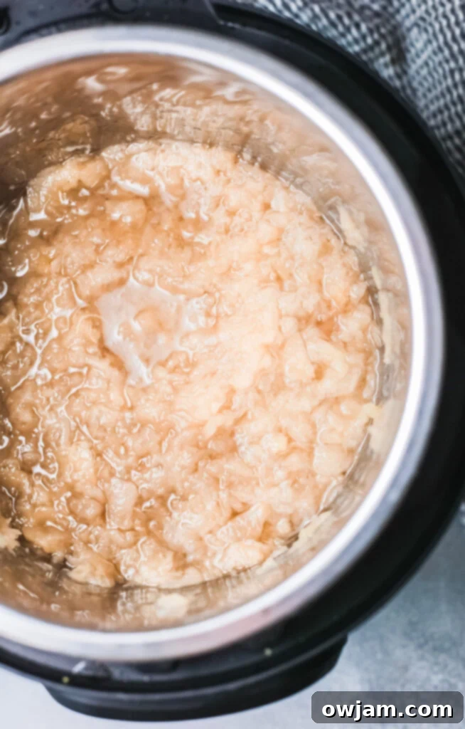 Effortless Instant Pot Applesauce 6 Instant Pot Applesauce being mashed in the Instant Pot.