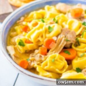 Hearty Chicken Tortellini Delight 8 Delicious Slow Cooker Chicken Tortellini Soup, garnished with fresh herbs and Parmesan.