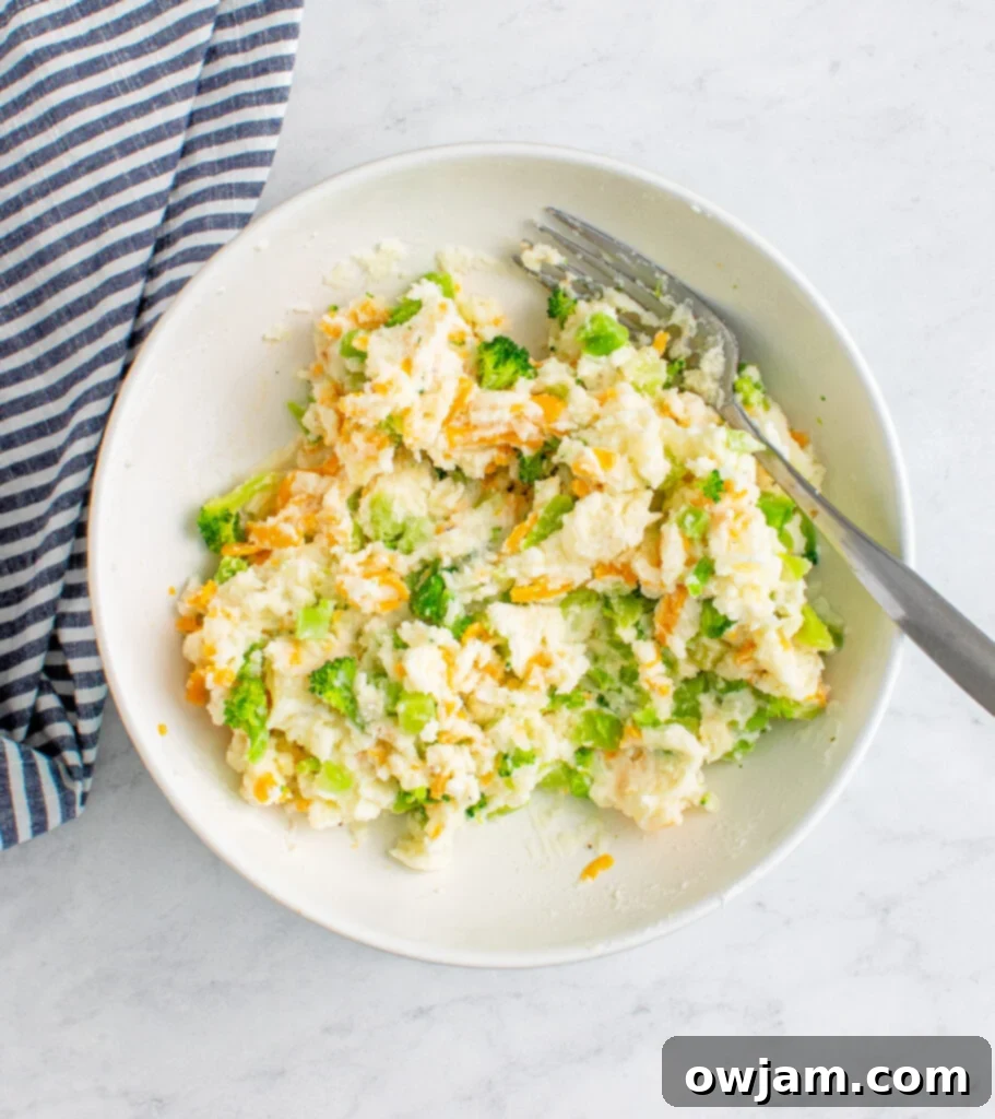 Mashed potato filling with broccoli and cheese in a bowl, ready for stuffing