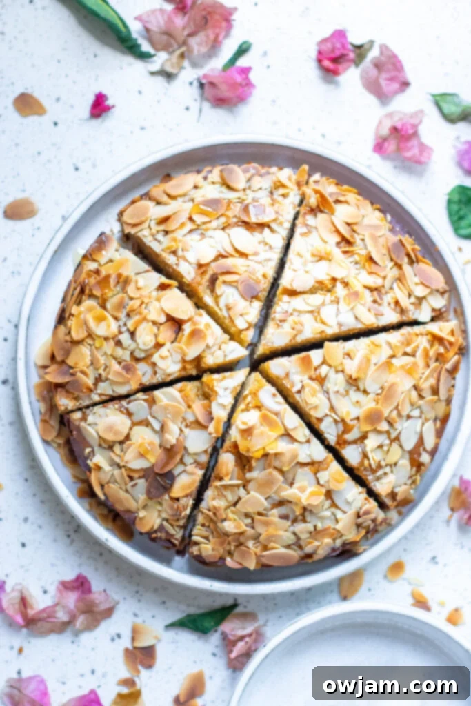 Irresistible Almond Cake 9 An inviting overhead view of a whole Honey Almond Cake, showcasing its perfectly even golden crust and generous toasted almond topping, ready for slicing