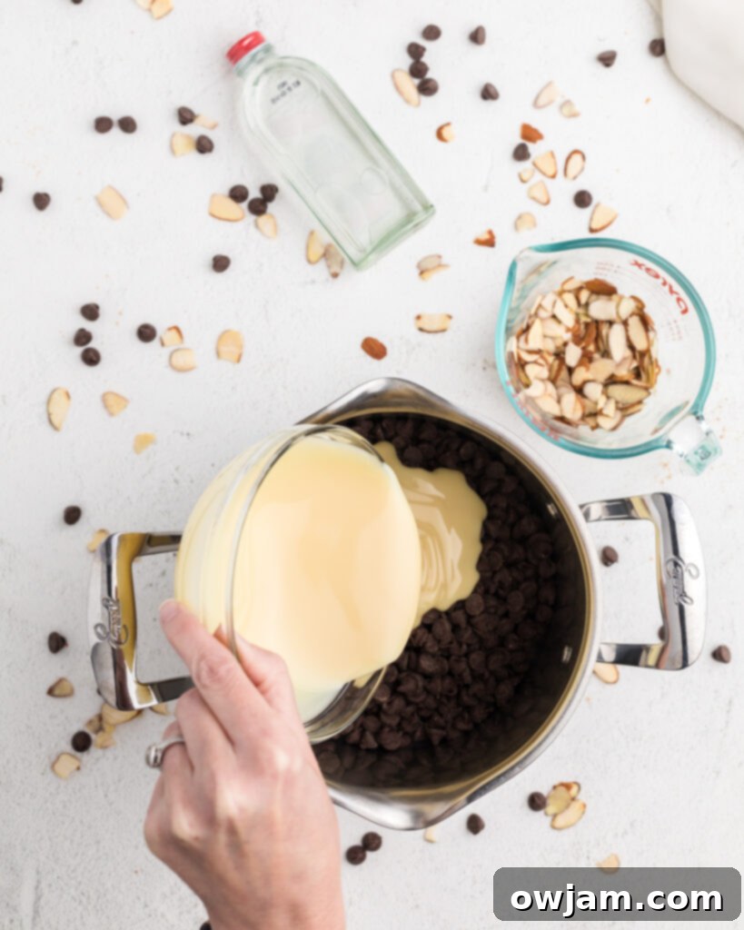 Chocolate chips and condensed milk melting in a saucepan for Easy Chocolate Fudge.
