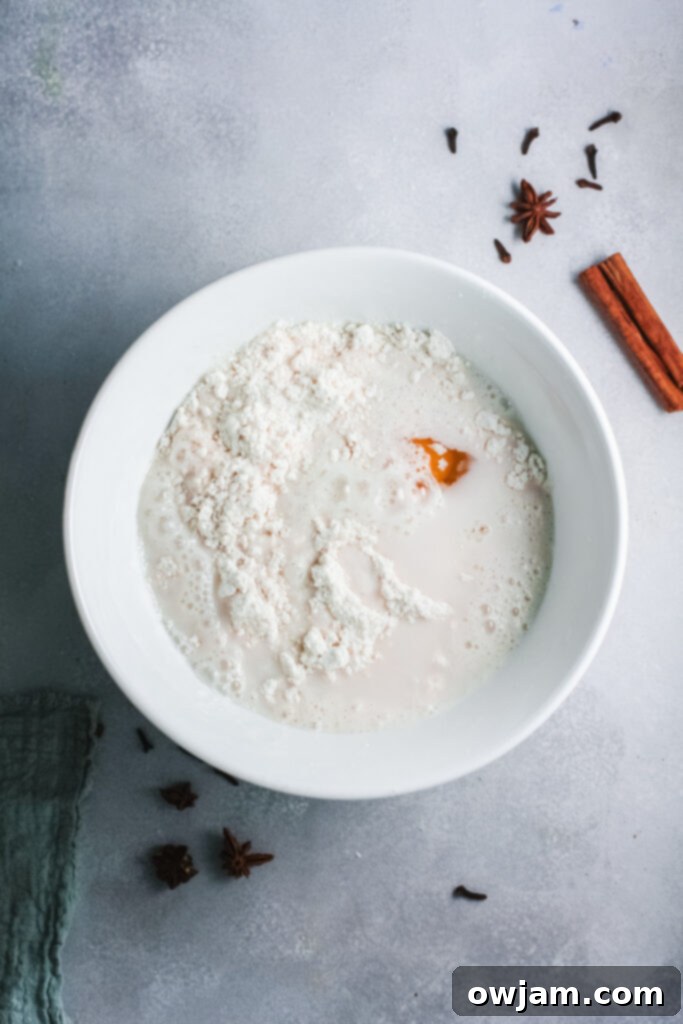 Eggnog Pancakes batter being sprinkled with nutmeg