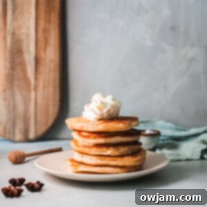 Eggnog Pancakes stack with cinnamon whipped cream and syrup