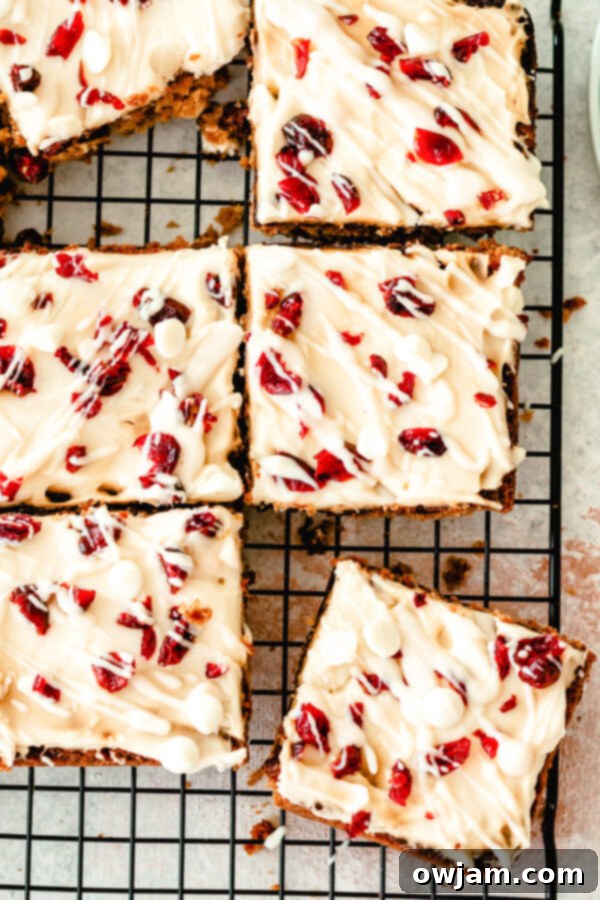 Freshly baked Cranberry Bliss Bars cooling on a wire rack, ready for frosting.