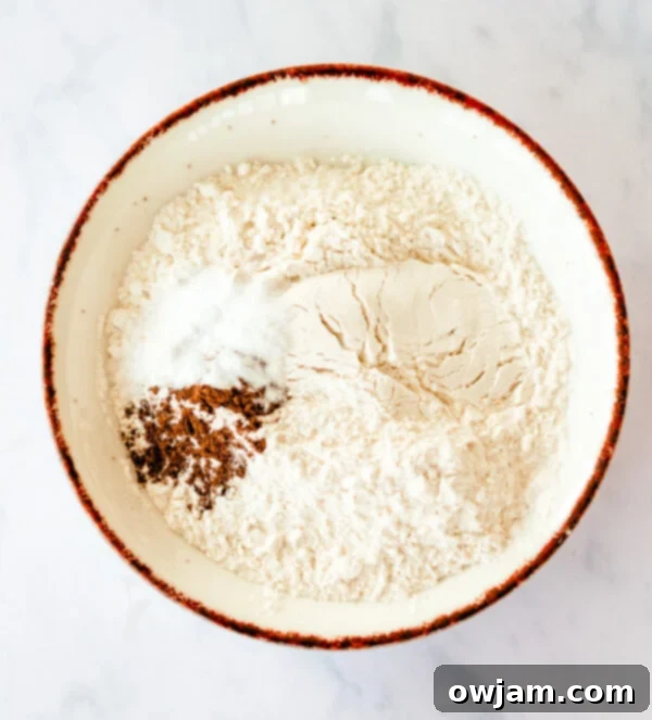 A bowl containing dry ingredients: flour, baking soda, salt, and cinnamon, perfectly mixed for the Cranberry Bliss Bars.
