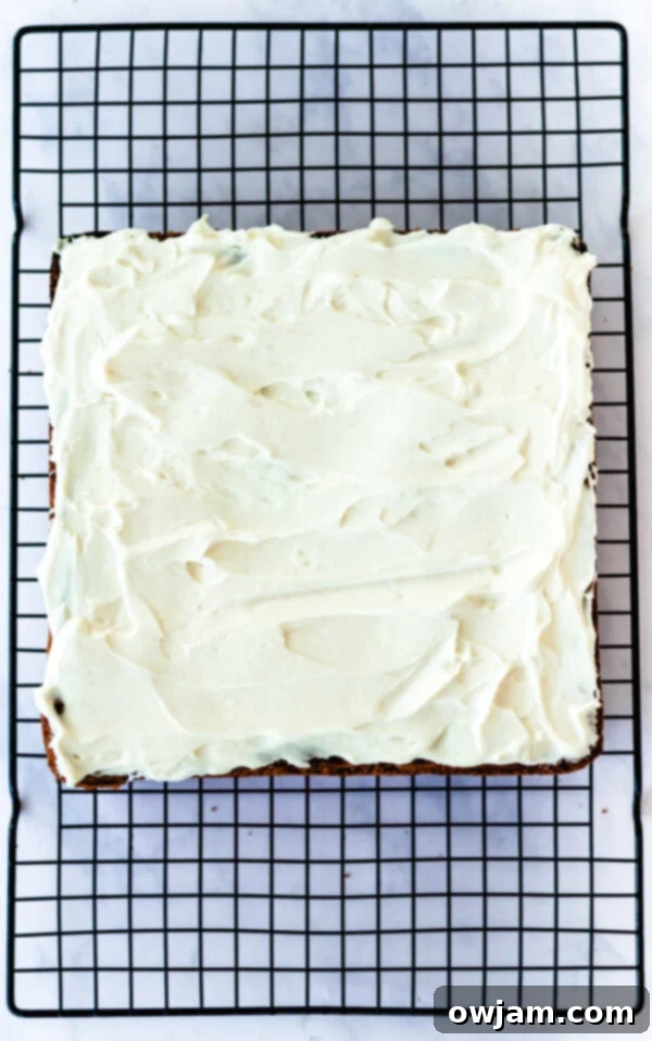 Close-up of fluffy cream cheese frosting being made in a bowl with a hand mixer, ready for Cranberry Bliss Bars.