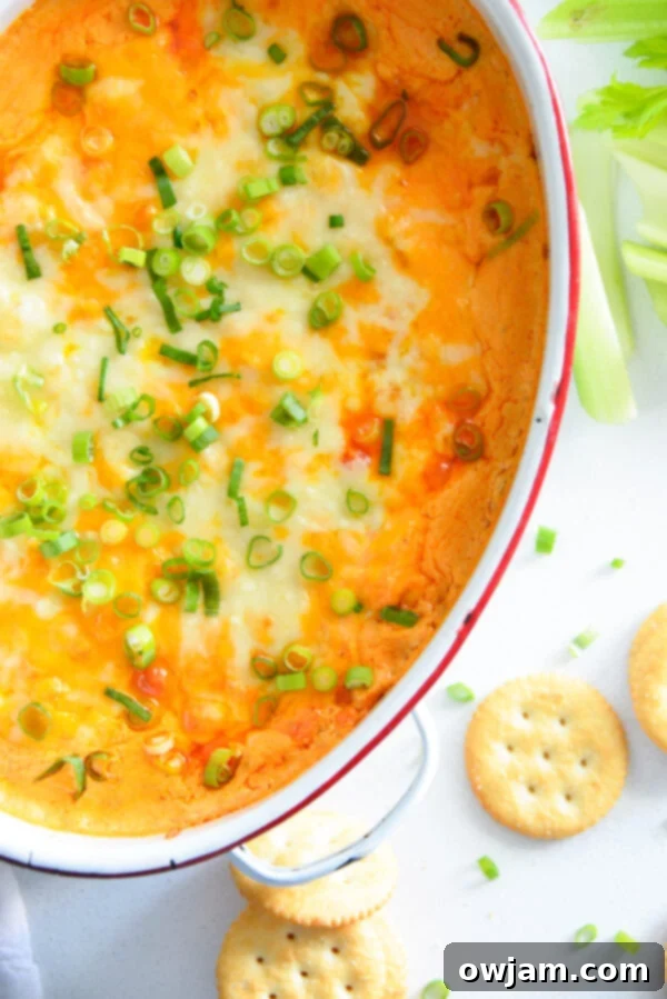 The Ultimate Buffalo Chicken Dip 2 Creamy Buffalo Chicken Dip served in a white bowl with a variety of dippers