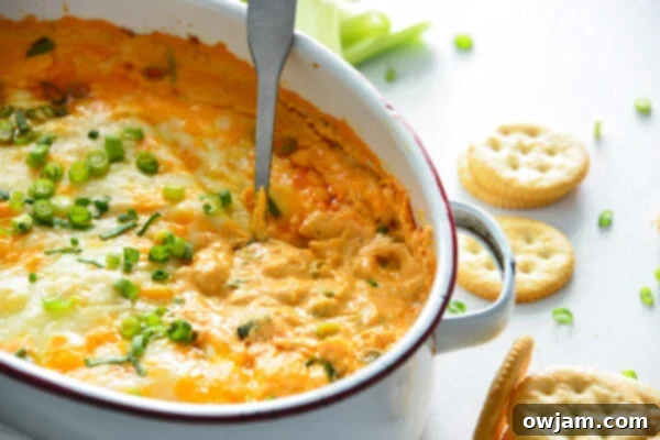 The Ultimate Buffalo Chicken Dip 11 Freshly baked Buffalo Chicken Dip in a white dish, garnished and ready to be served