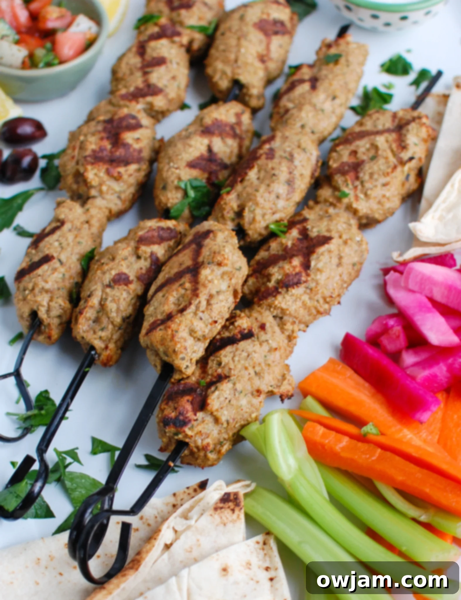 Chicken Meatballs 2 Platter of perfectly grilled Chicken Kofta kebabs garnished with fresh herbs, ready to serve.