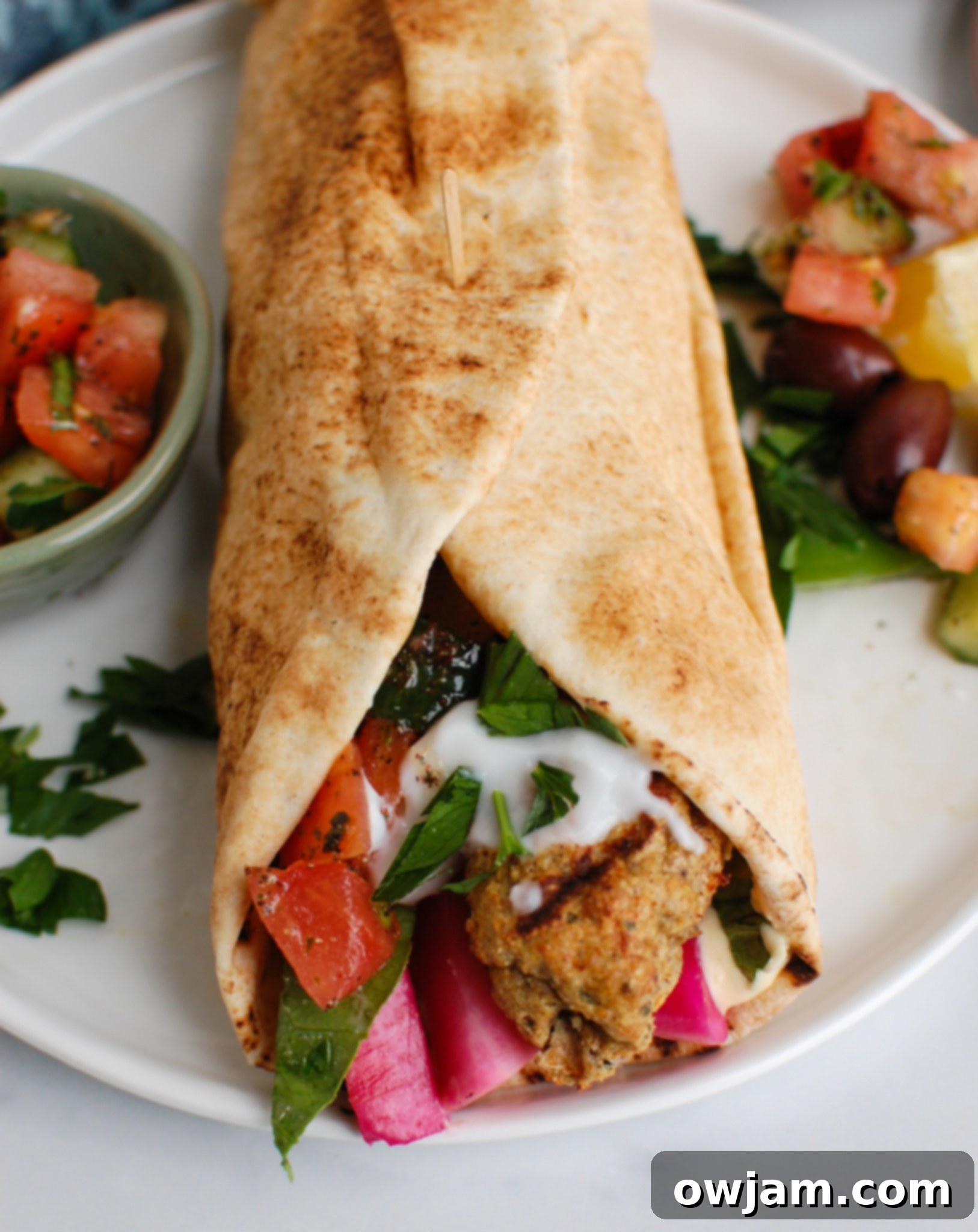 Chicken Meatballs 3 Close-up of Chicken Kofta wrapped in a pita with fresh vegetables and sauce.