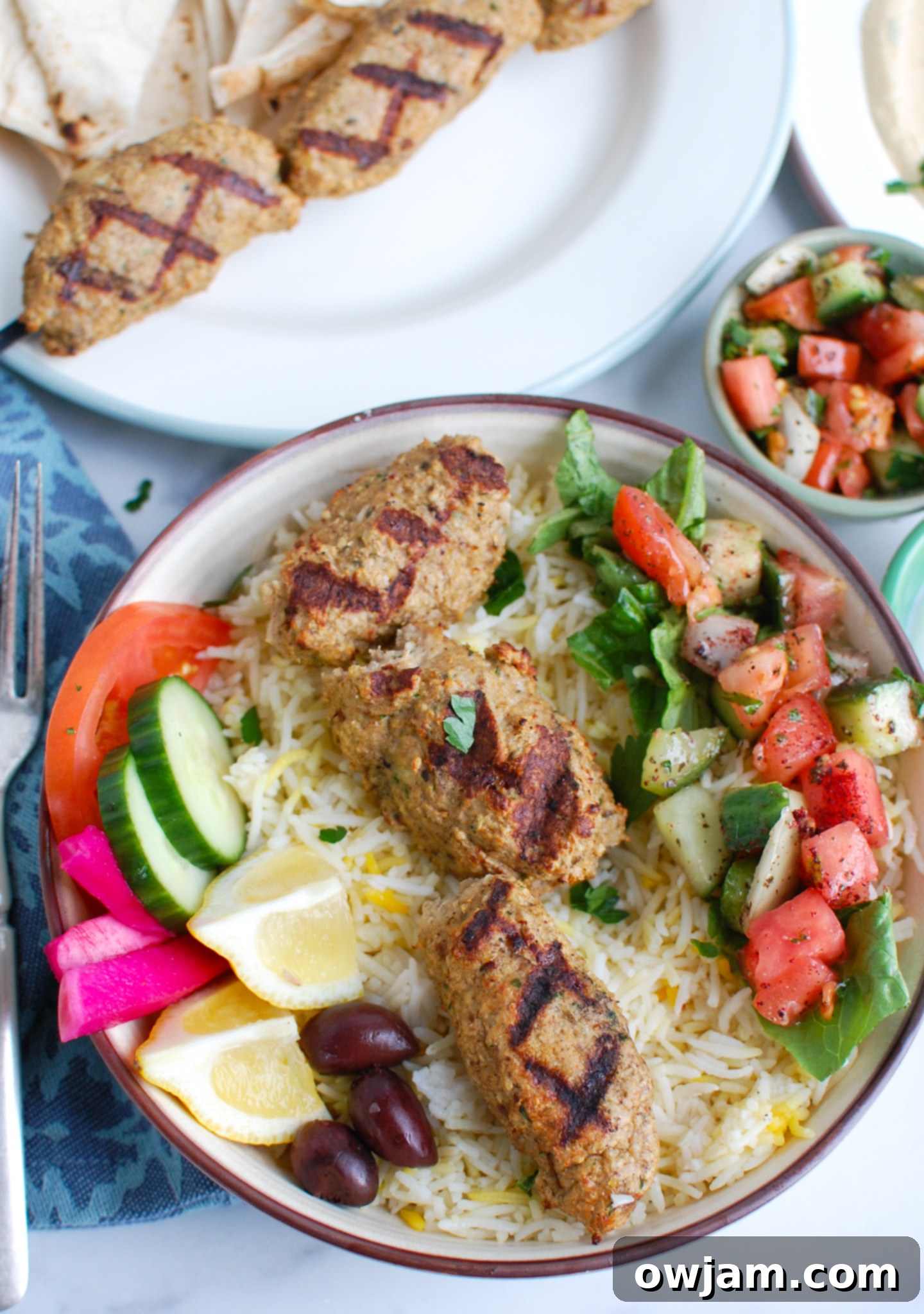 Chicken Meatballs 8 A chicken kofta kebab served over a bed of fluffy rice in a bowl.