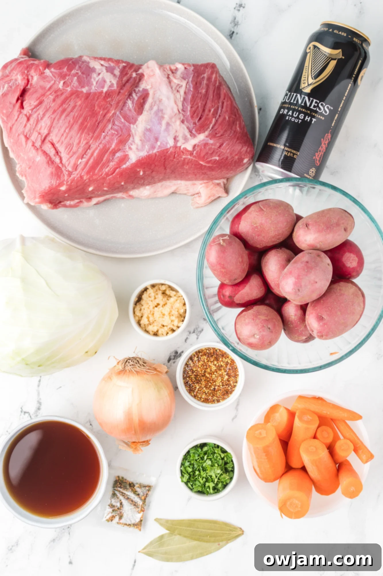 Tender Instant Pot Corned Beef and Cabbage 5 Raw Instant Pot Corned Beef and Cabbage ingredients laid out: brisket, cabbage, potatoes, carrots, onions, garlic, beer, broth