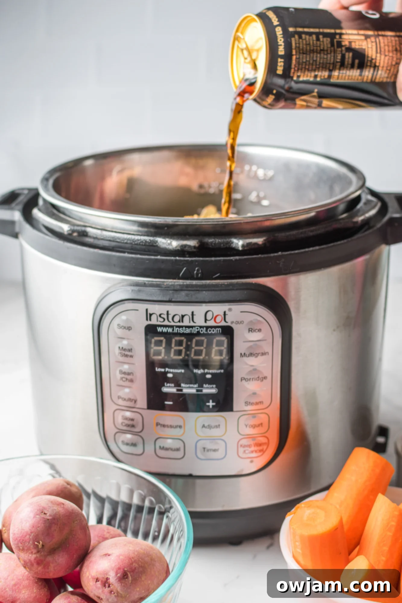 Tender Instant Pot Corned Beef and Cabbage 9 Pouring beer and broth over corned beef in the Instant Pot