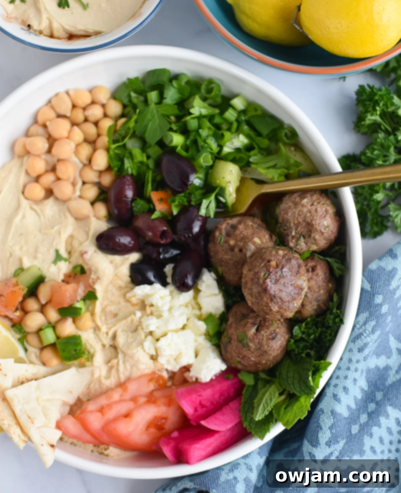 Lamb Kofta in hummus bowl with fork. Delicious and healthy Mediterranean meal idea.