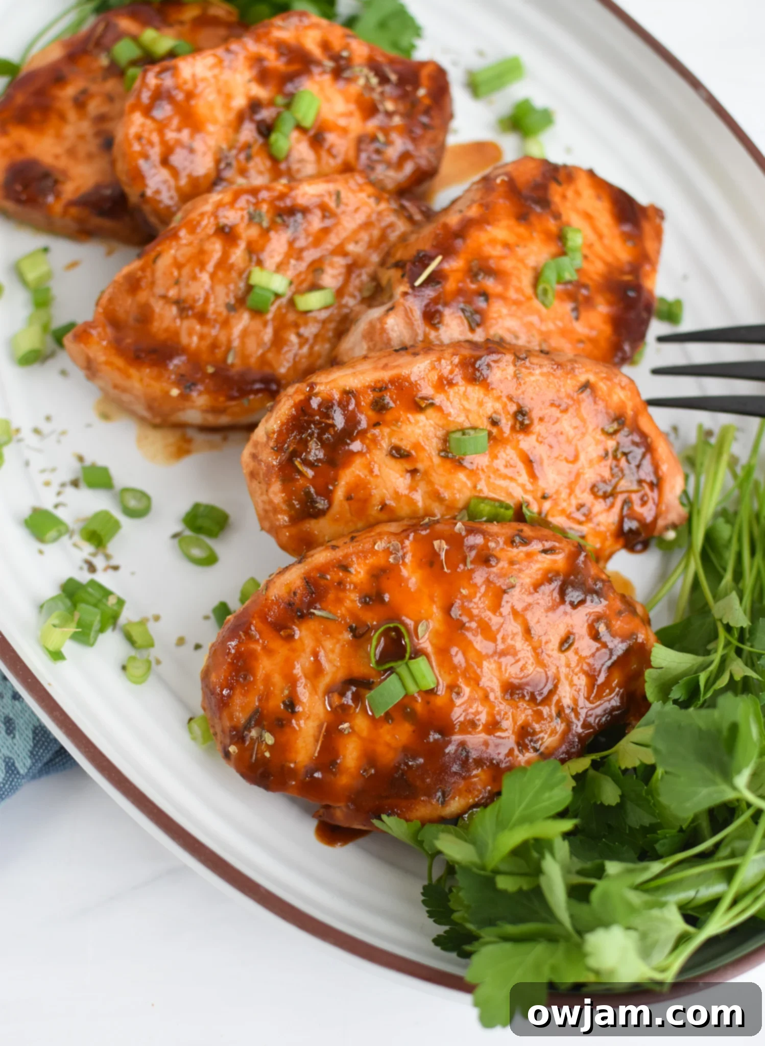 Mouthwatering BBQ Baked Pork Chops 2 Platter of golden brown BBQ Baked Pork Chops garnished with fresh herbs, ready to serve.