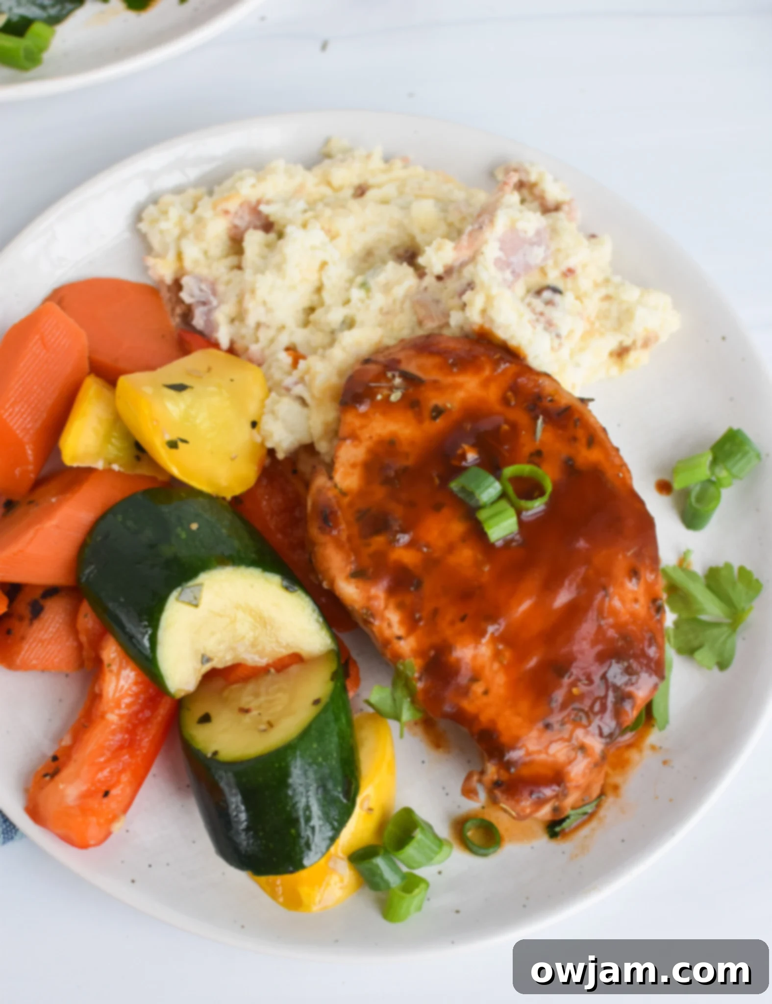 Mouthwatering BBQ Baked Pork Chops 7 Complete meal featuring BBQ Baked Pork Chops served with mashed potatoes and green beans on a plate.