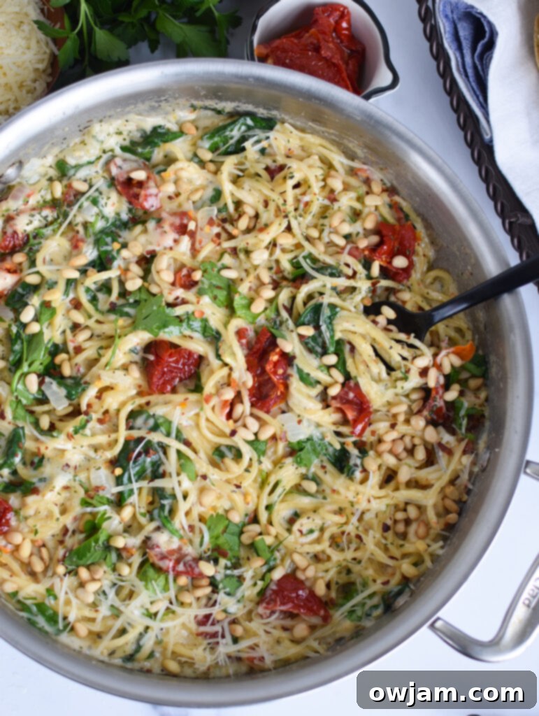 Creamy Sun-Dried Tomato Pasta 2 Creamy Sun Dried Tomato Pasta Recipe with a spoon in the pan, highlighting the rich sauce and ingredients.