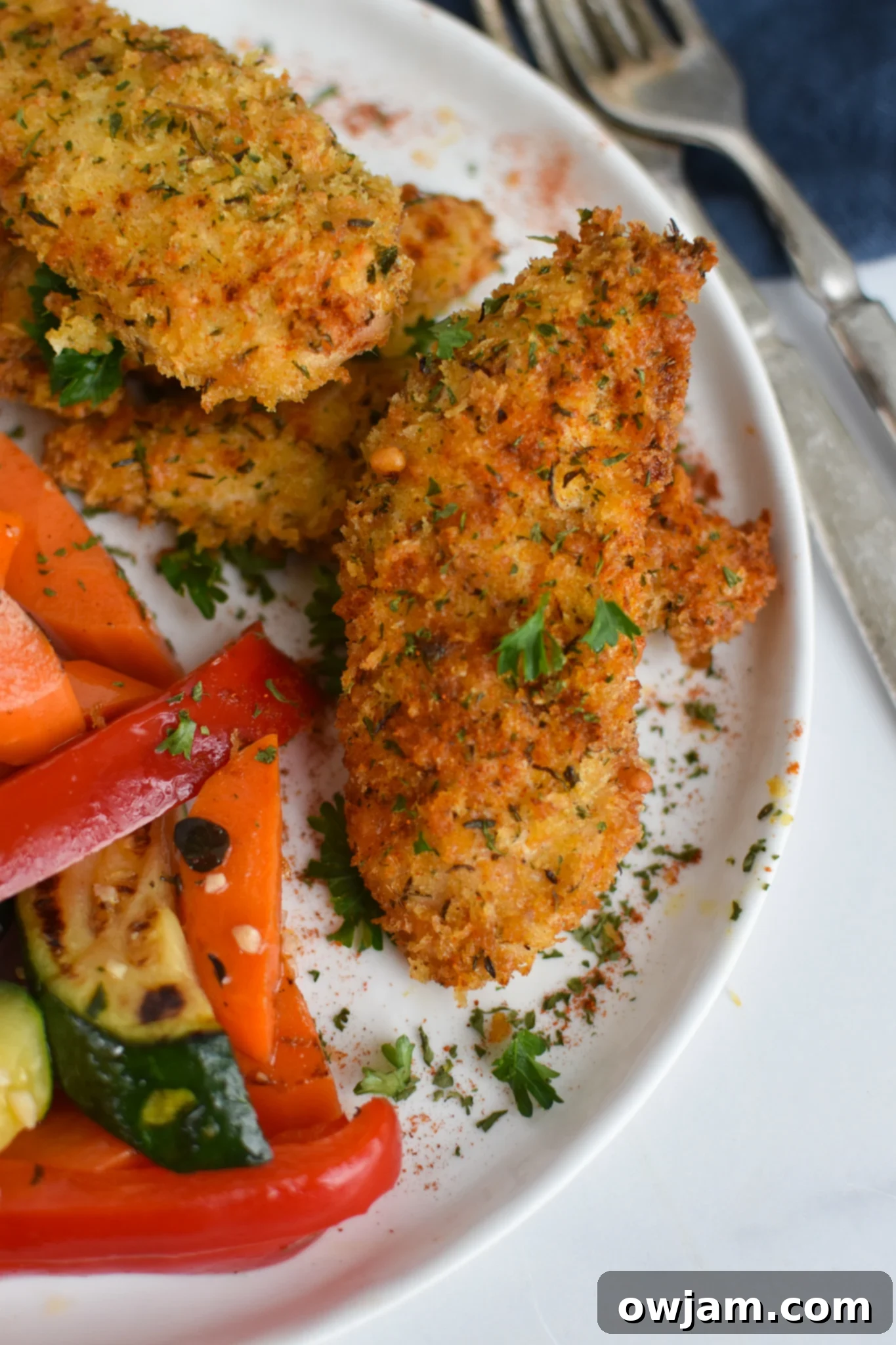 Crispy Air Fryer Chicken Tenders 5 Air Fryer Chicken Tenders served with fresh vegetables on a plate.
