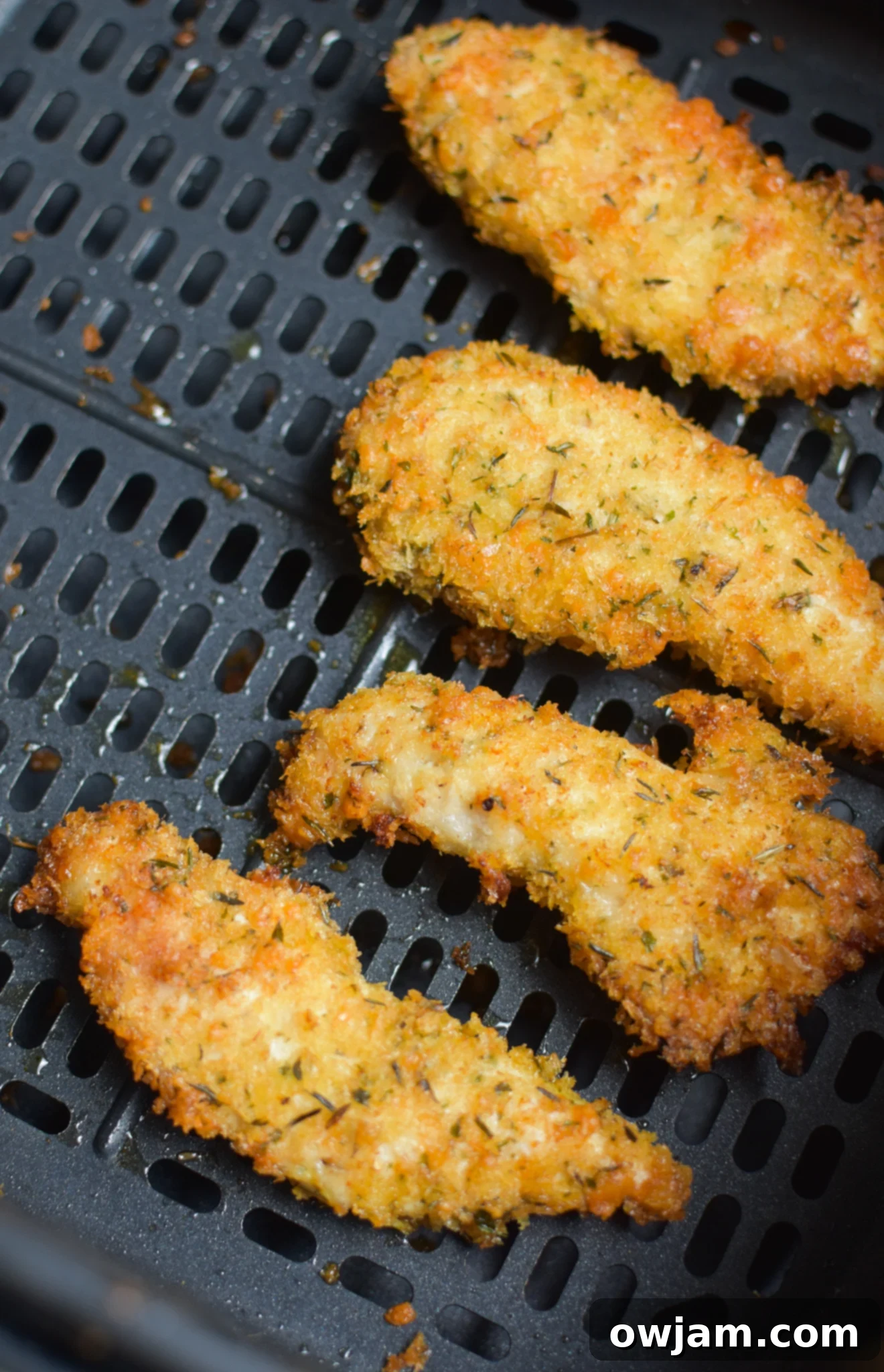 Crispy Air Fryer Chicken Tenders 7 Air Fryer Chicken Tenders cooking inside an air fryer basket.
