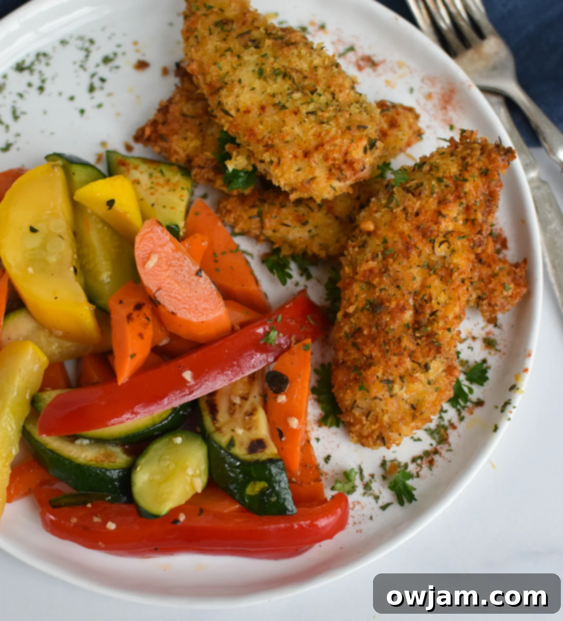 Crispy Air Fryer Chicken Tenders 8 Plated Air Fryer Chicken Tenders garnished with fresh parsley.
