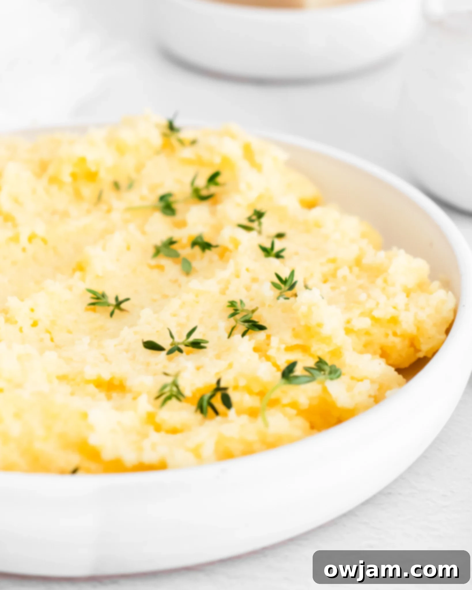 Silky Smooth Polenta Perfection 2 Creamy Polenta Recipe with fresh thyme in a bowl.