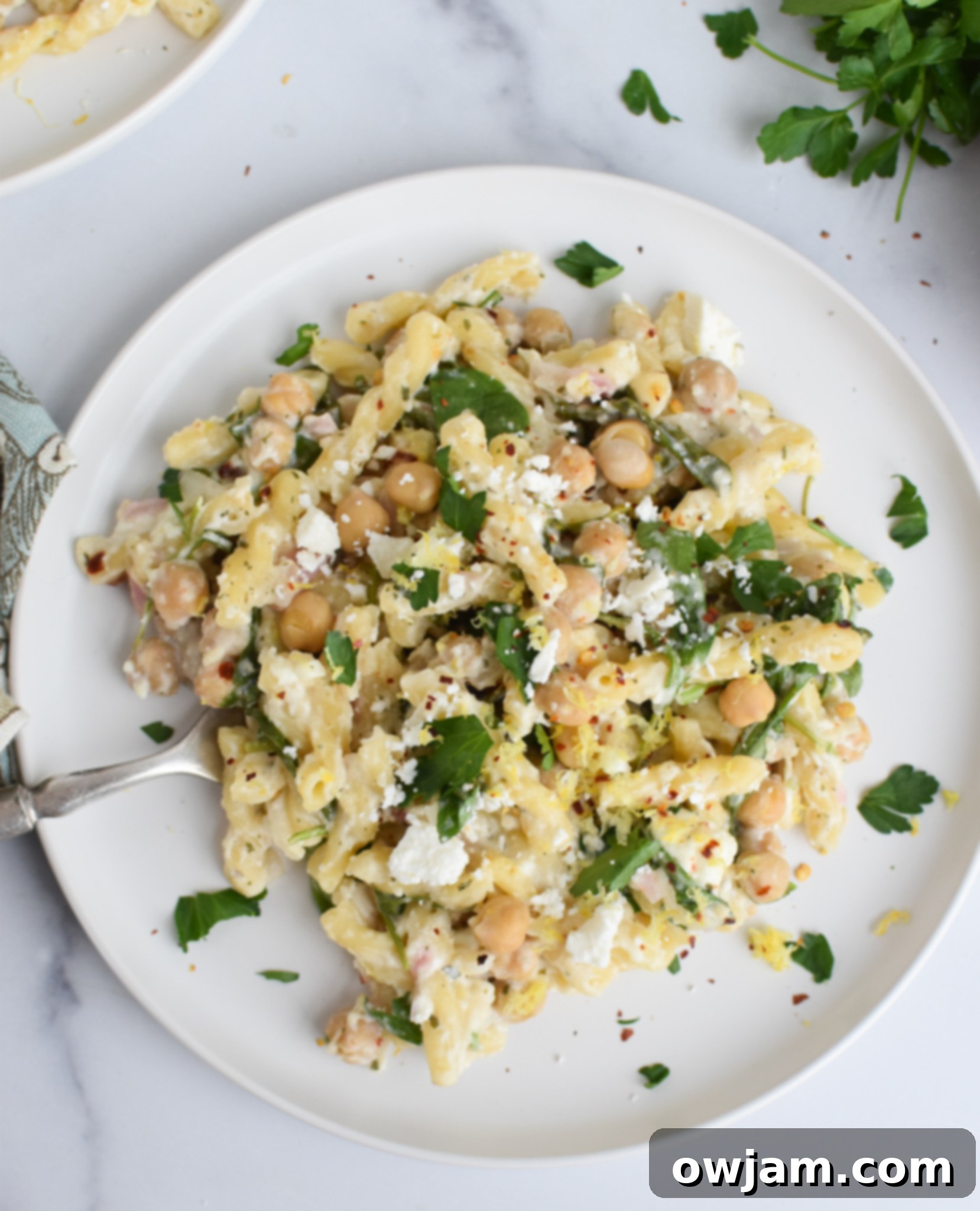 Mediterranean Chickpea Pasta with Feta 5 A close-up of Chickpea Pasta Recipe with Feta served on a white plate, garnished with fresh parsley.