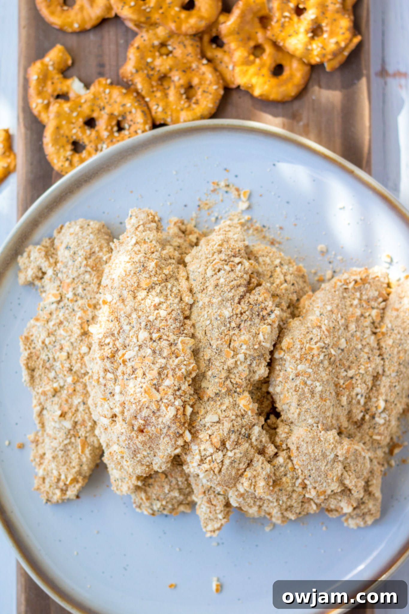 Crunchy Pretzel Chicken 6 A serving of crispy Pretzel Crusted Chicken Tenders arranged on a plate with dipping sauce.