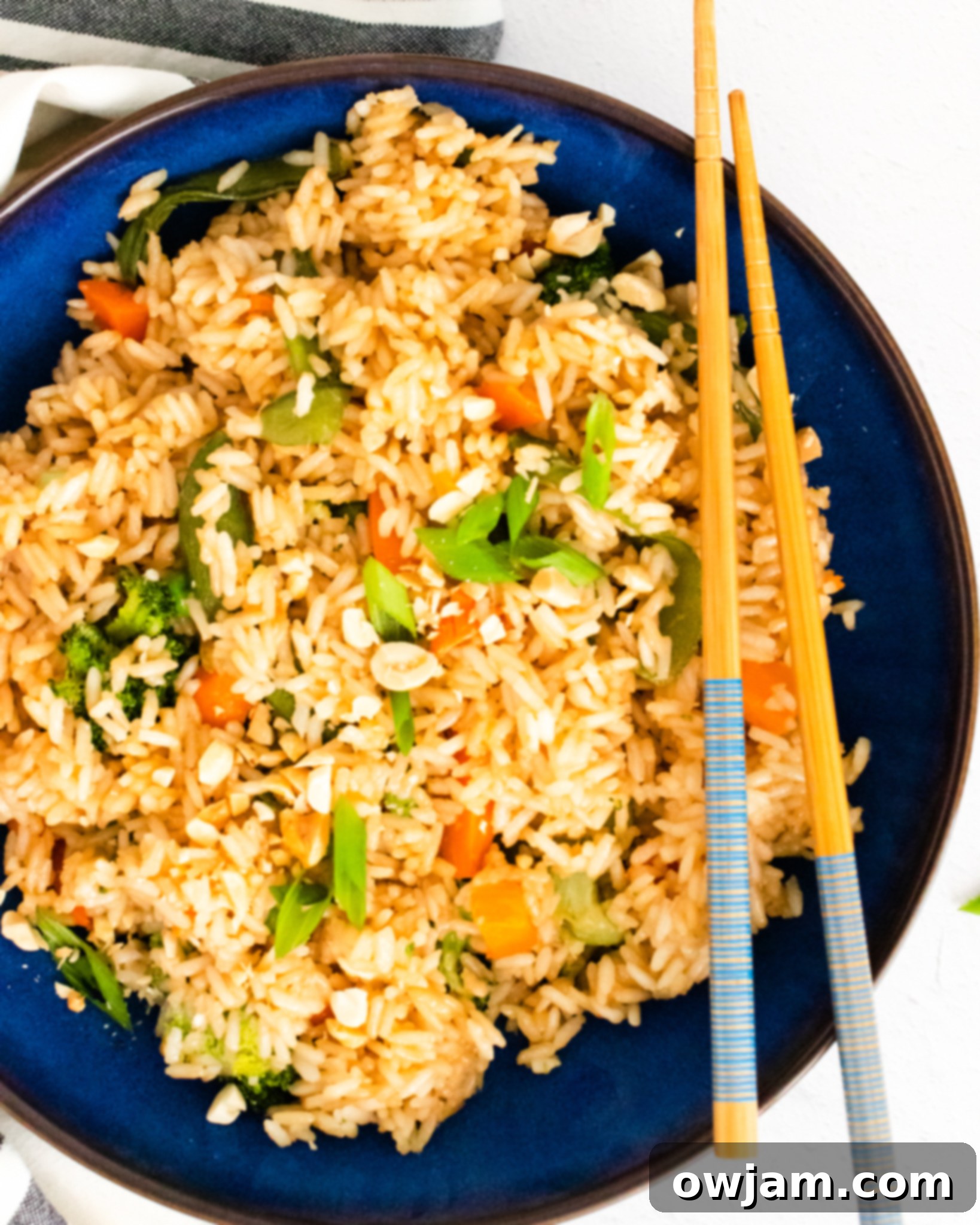 Effortless Instant Pot Fried Rice 2 Instant Pot Fried Rice in a blue bowl, garnished with green onions and sesame seeds.