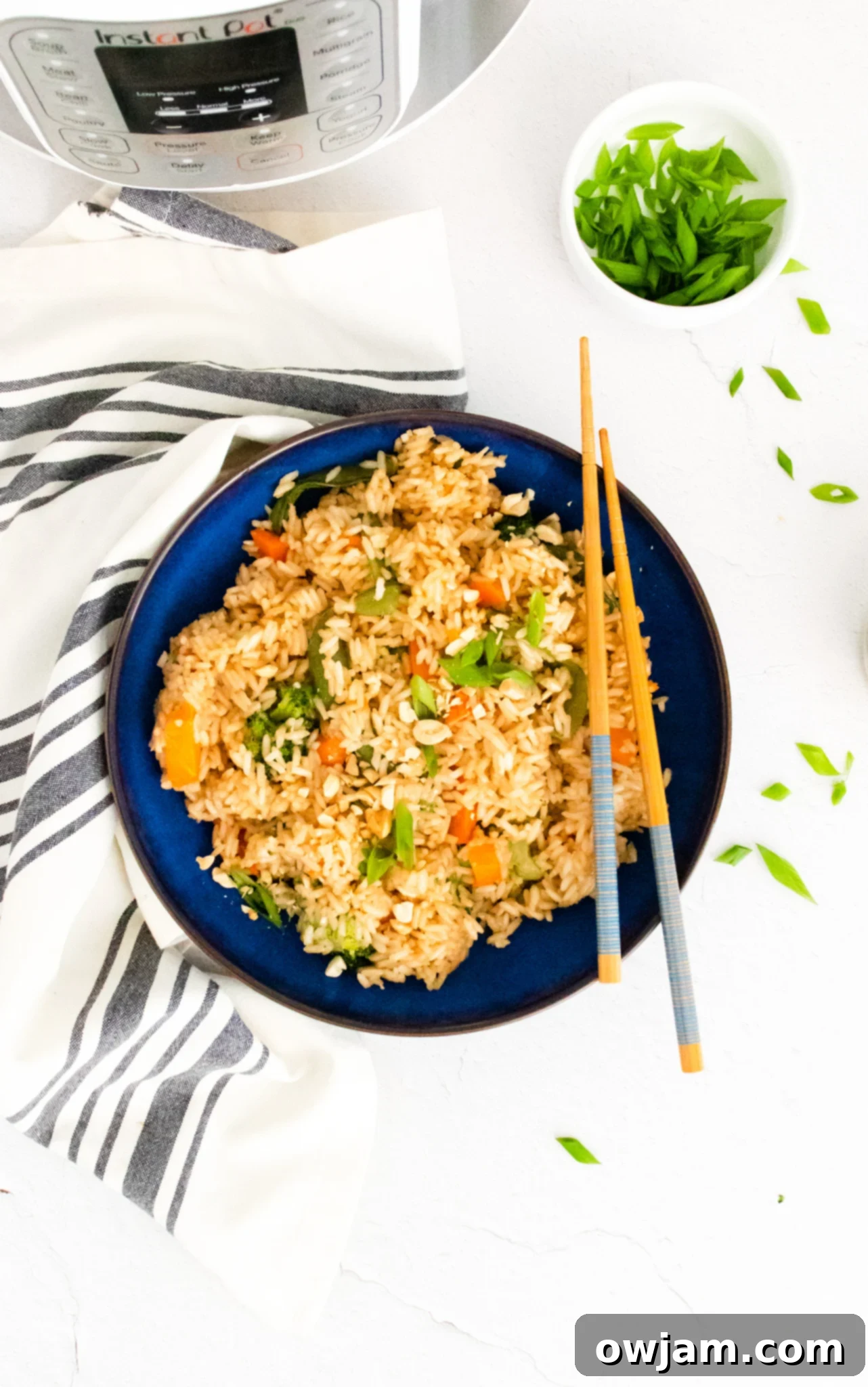 Effortless Instant Pot Fried Rice 6 Instant Pot Fried Rice in a blue bowl with chopsticks resting on the side.