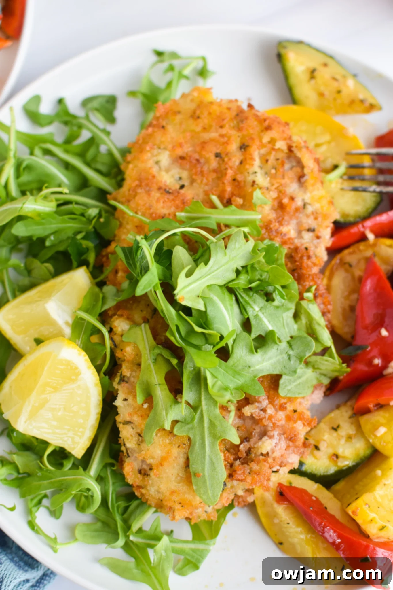 Effortless Homemade Veal Milanese 2 Easy Veal Milanese Recipe served with fresh arugula and lemon wedges.