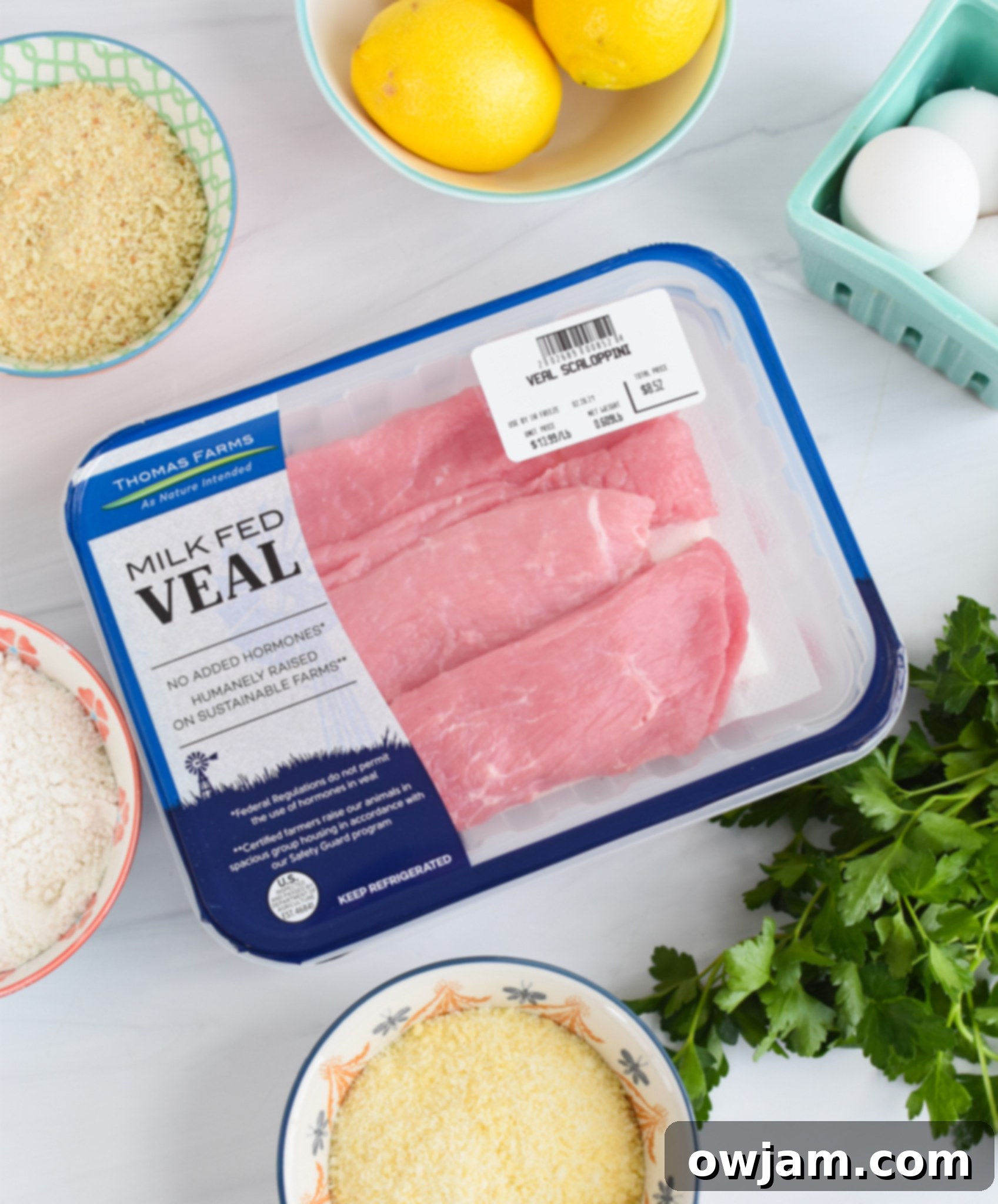 Effortless Homemade Veal Milanese 3 Ingredients laid out for Easy Veal Milanese Recipe: veal, eggs, flour, breadcrumbs, Parmesan, and herbs.