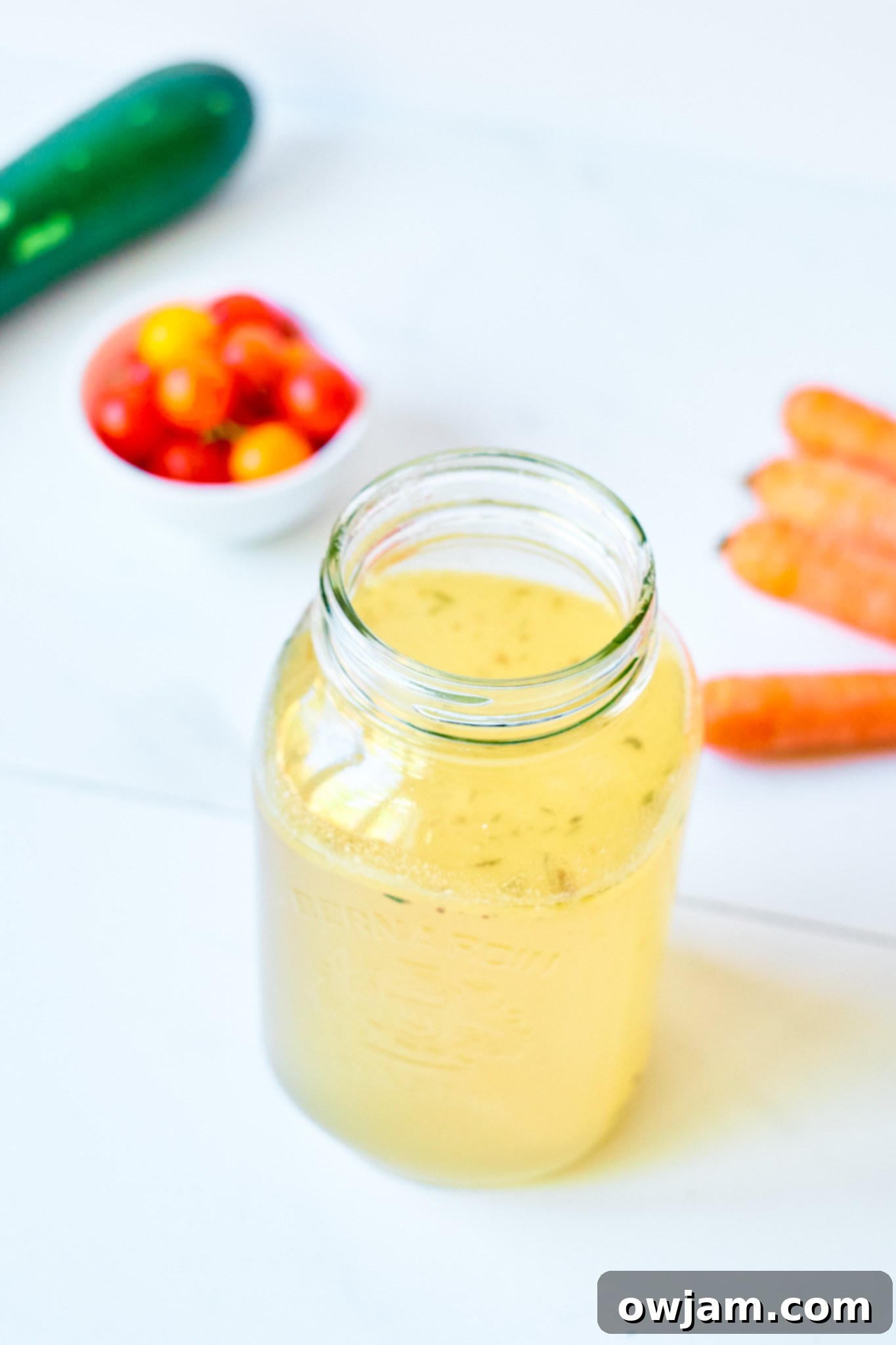 Effortless Homemade Beef Bone Broth 2 Easy Beef Bone Broth Recipe in a glass jar, showing its rich, golden color and gelatinous texture.