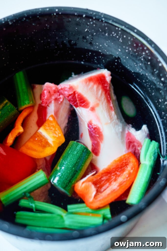 Effortless Homemade Beef Bone Broth 5 A large pot of Easy Beef Bone Broth simmering on the stove, rich with roasted beef bones and fresh vegetables, creating a deeply flavored base.