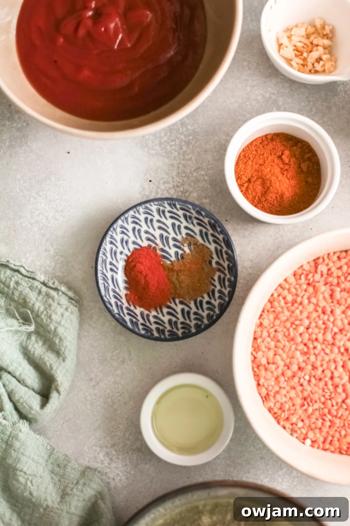 Assorted ingredients for Red Lentil Curry laid out on a wooden surface.