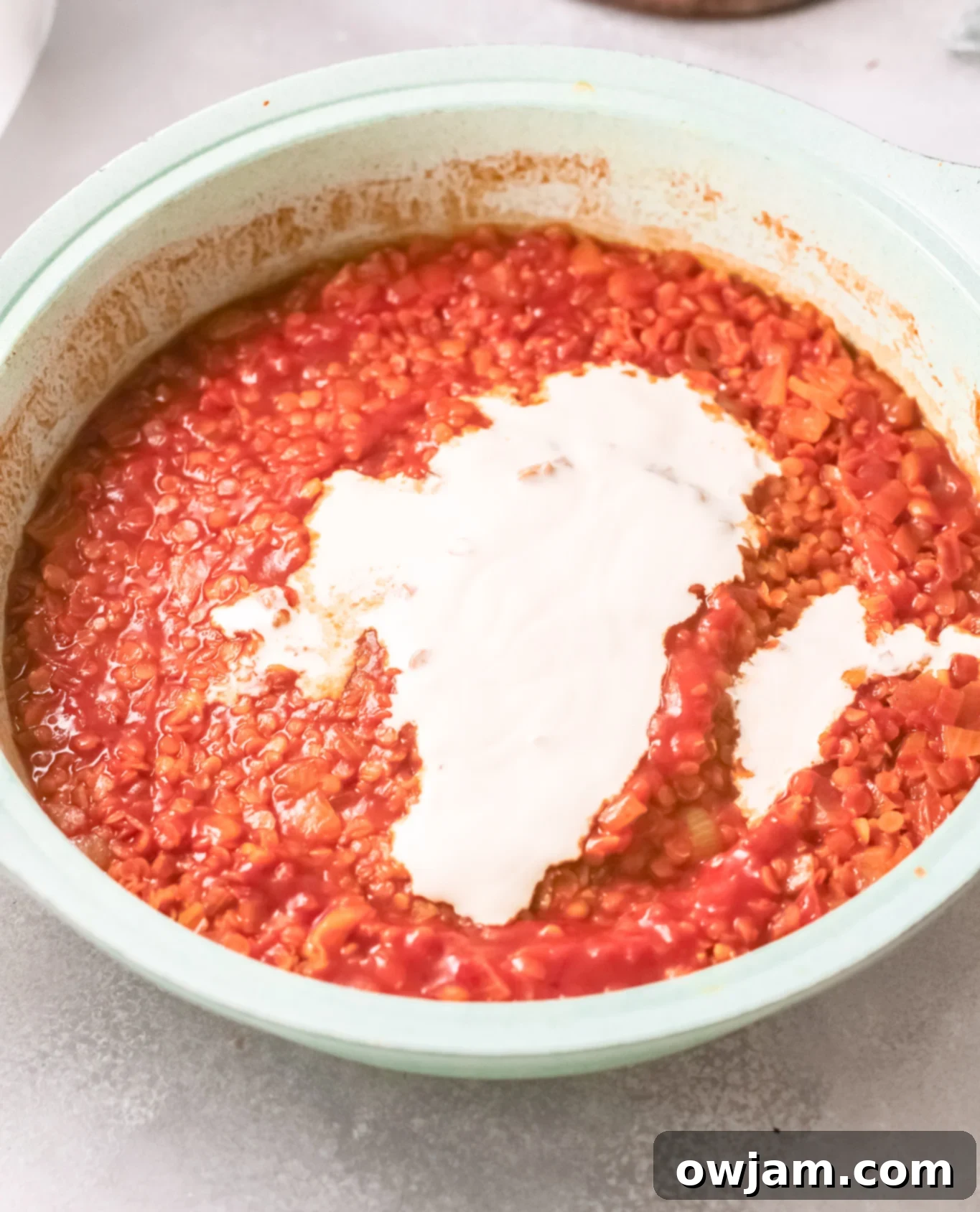 Red Lentil Curry with a swirl of coconut cream, ready to be served.