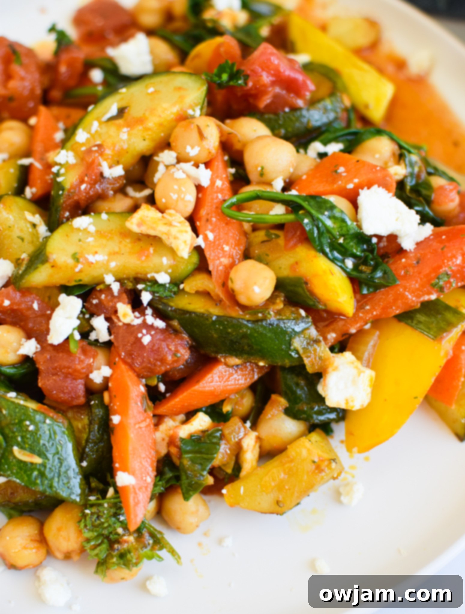 Vibrant Mediterranean Chickpea Skillet 2 Vibrant Mediterranean Chickpea Skillet garnished with feta cheese and fresh parsley, ready to be served for a healthy, quick dinner.