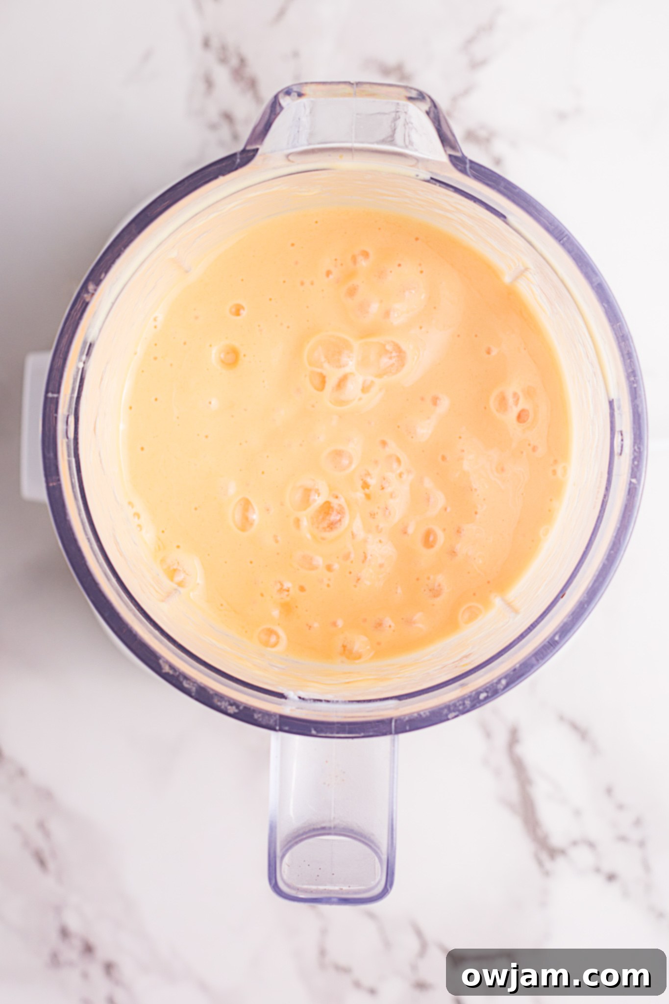 Freshly blended Mango Lassi in a blender, ready to be poured.