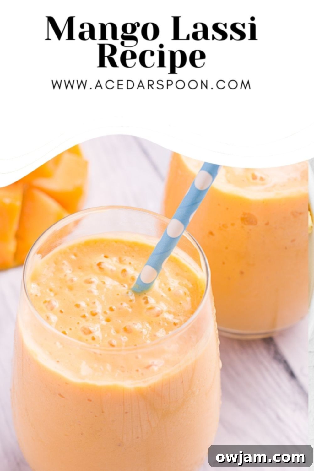 A glass of homemade Mango Lassi with a logo overlay, showing its smooth texture.