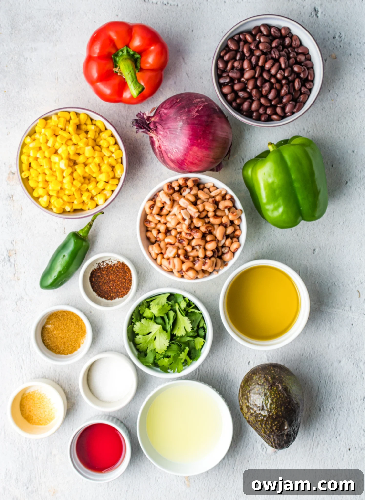 Fresh ingredients for Cowboy Caviar Recipe laid out on a cutting board.