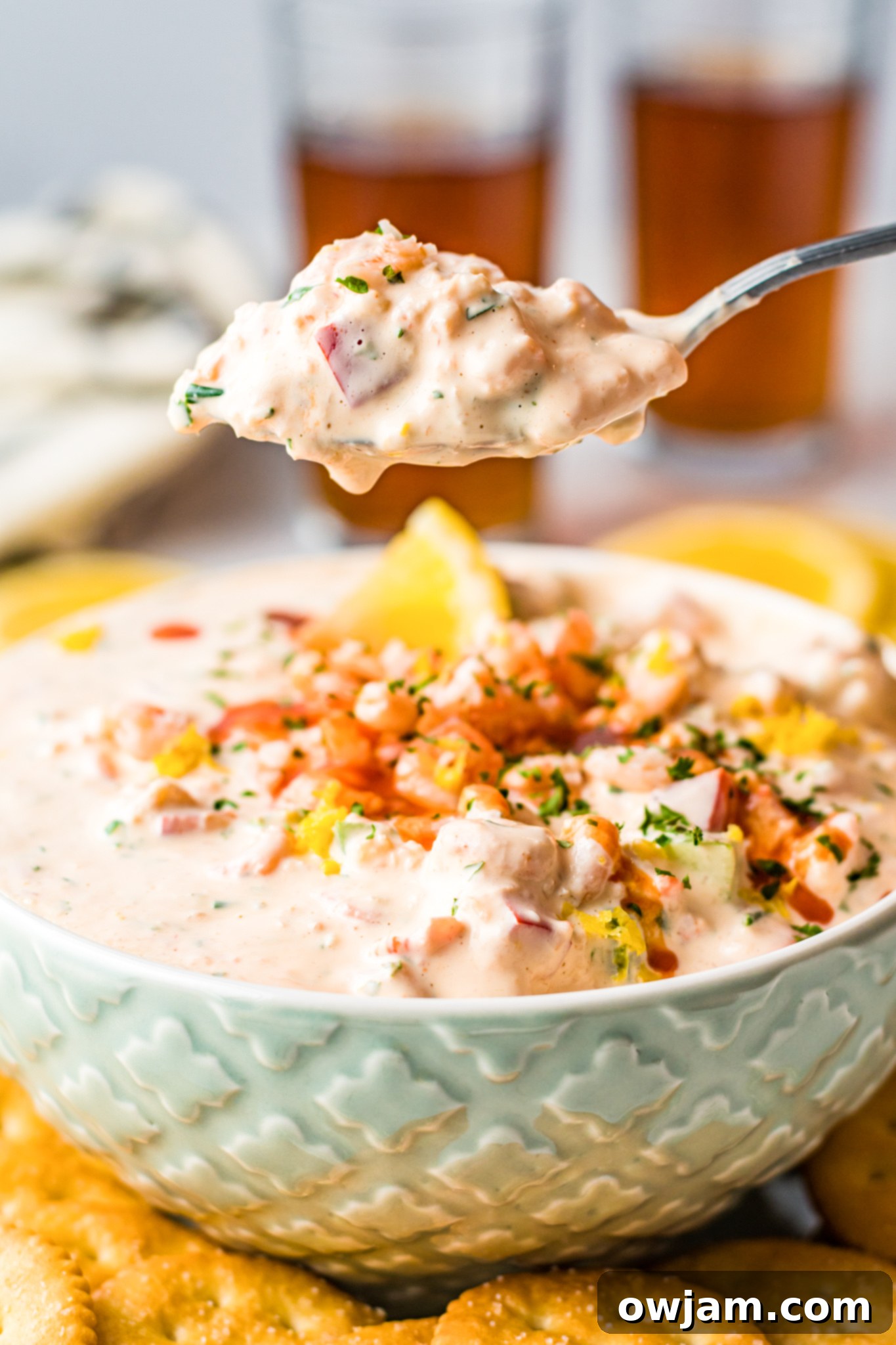 Irresistible Shrimp Dip 9 Shrimp Dip Recipe in a light blue bowl with a serving spoon.