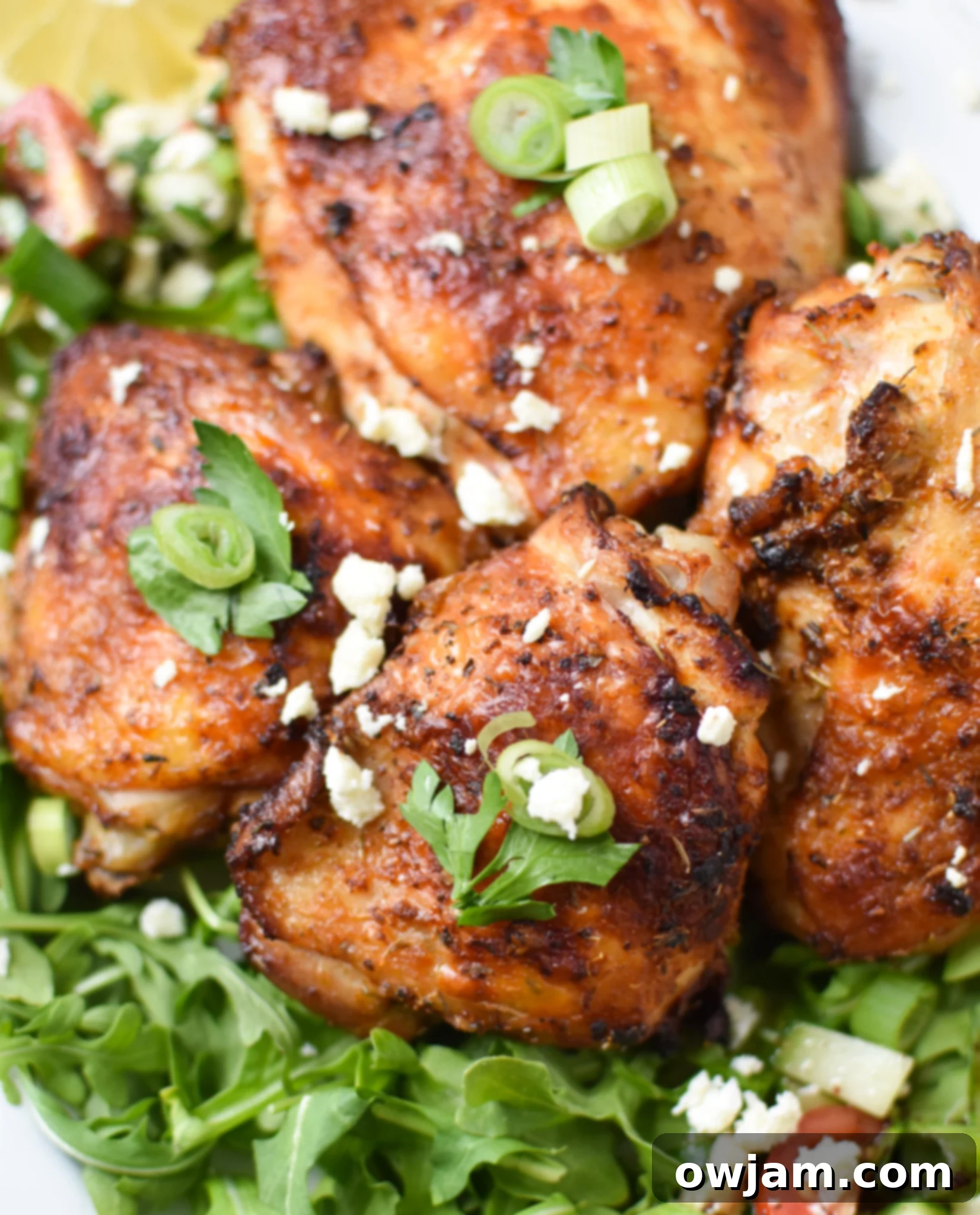 Close-up of Air Fryer Mediterranean Chicken Thighs on a white platter, ready to be served.